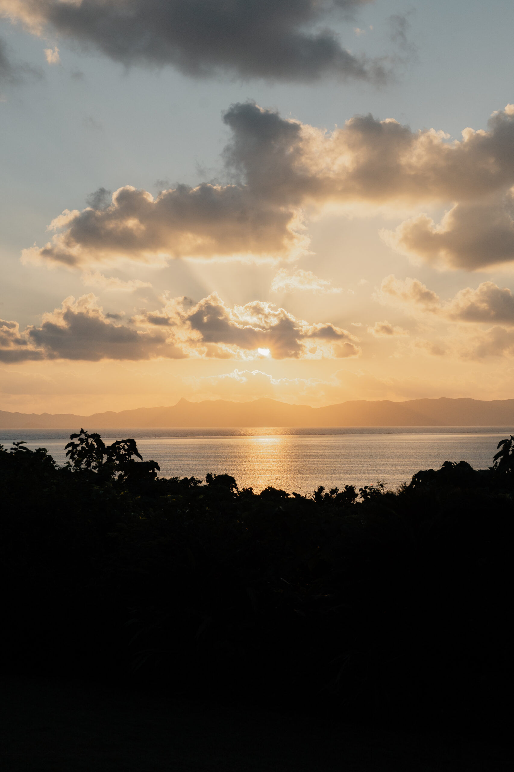石垣島の海と雲の間から差す夕日